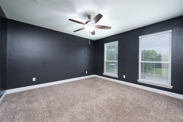 empty room with baseboards, a ceiling fan, and carpet floors