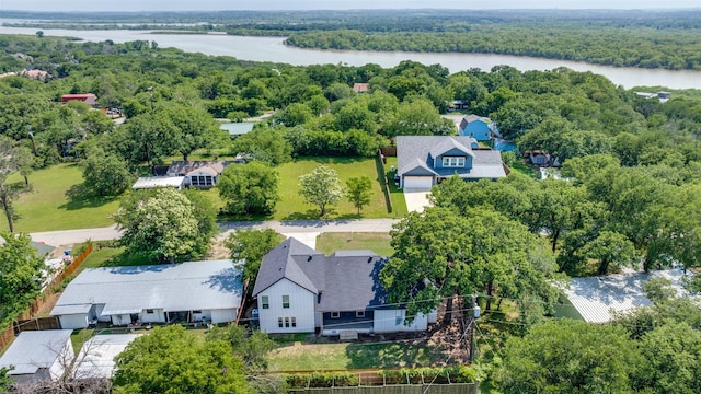 birds eye view of property with a wooded view and a water view