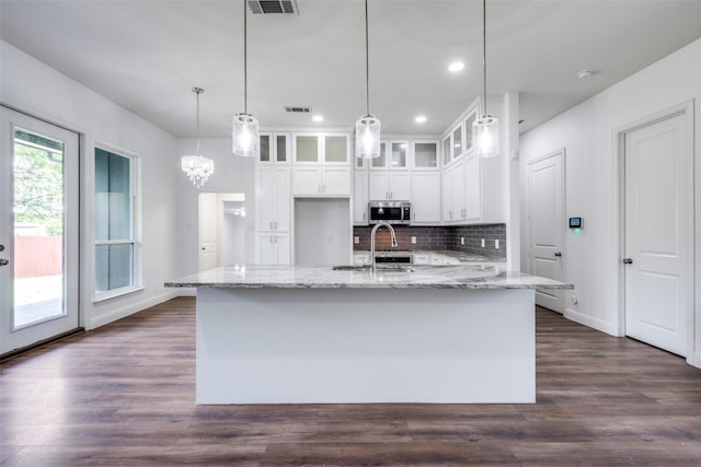 kitchen with stainless steel microwave, recessed lighting, dark wood-style flooring, decorative backsplash, and white cabinetry