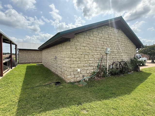 view of home's exterior with metal roof and a yard