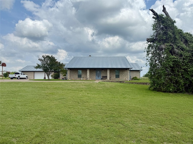 view of front of property with metal roof, a front lawn, and driveway