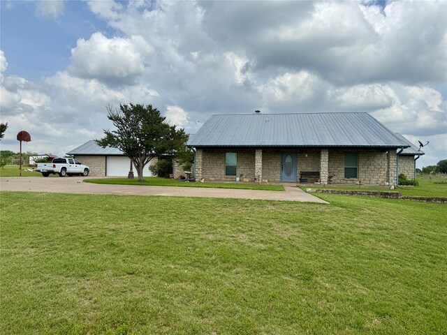 view of front of home with metal roof, concrete driveway, and stone siding