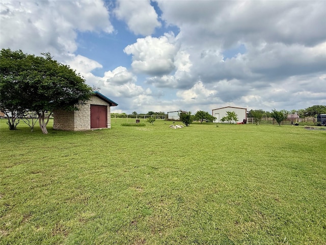 view of yard with fence, an outdoor structure, and a shed