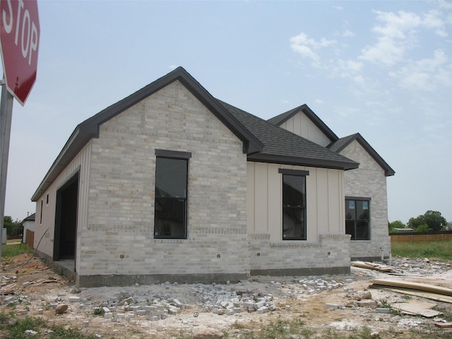 201 Cliff Ct, Godley, TX 76044 - back of house featuring board and batten siding and brick siding