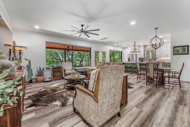 11900 Wind Hollow Ct, Tolar, TX 76476 - living room featuring ornamental molding, a chandelier, recessed lighting, healthy amount of natural light, and light wood-style floors