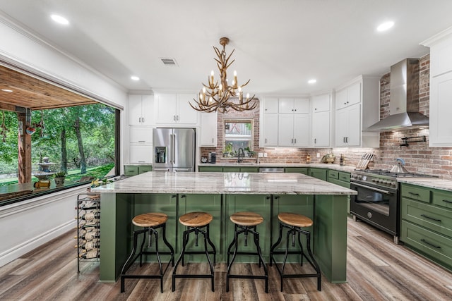 11900 Wind Hollow Ct, Tolar, TX 76476 - kitchen with green cabinets, high quality appliances, wall chimney range hood, white cabinets, and recessed lighting
