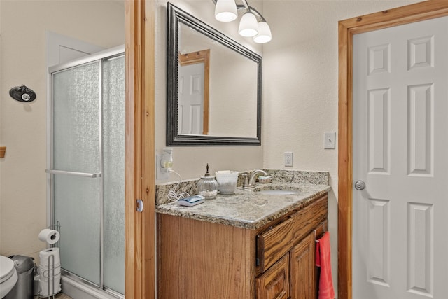 full bathroom featuring toilet, vanity, and a stall shower