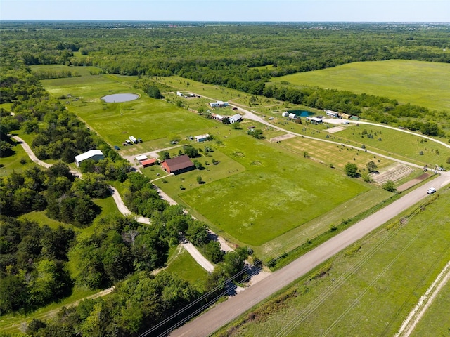 drone / aerial view featuring a rural view and a view of trees
