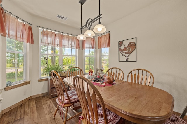 dining area with visible vents, hardwood / wood-style floors, and baseboards