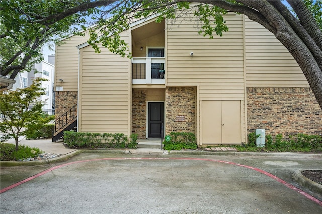view of front of home featuring brick siding and uncovered parking