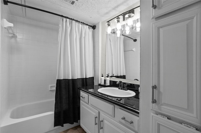 bathroom with vanity, a textured ceiling, tile patterned flooring, and shower / tub combo with curtain