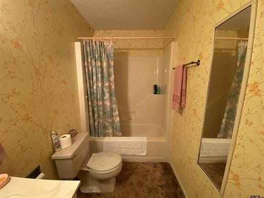 bathroom with shower / bath combo, vanity, toilet, a textured ceiling, and wallpapered walls