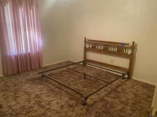 unfurnished bedroom with baseboards and carpet