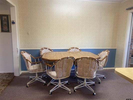 dining room featuring carpet, wallpapered walls, and baseboards