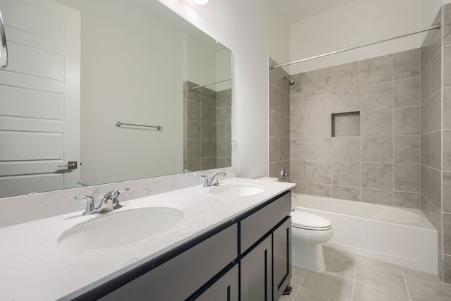 bathroom featuring toilet, shower / bathtub combination, tile patterned flooring, and a sink
