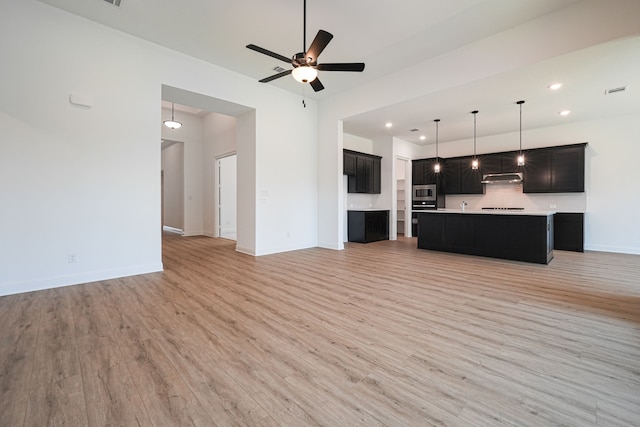 unfurnished living room featuring recessed lighting, a ceiling fan, baseboards, and light wood-style floors