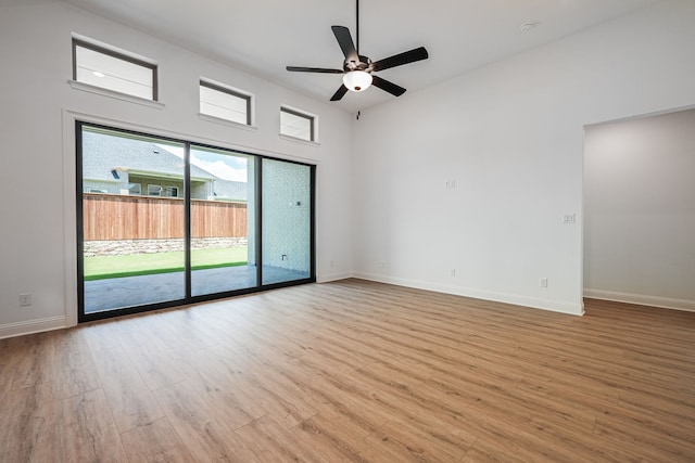 empty room with a ceiling fan, wood finished floors, and baseboards