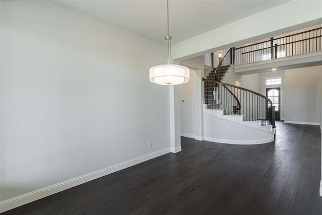 3406 Tilley Ct, Rockwall, TX 75087 - unfurnished dining area with dark wood finished floors, baseboards, and stairs