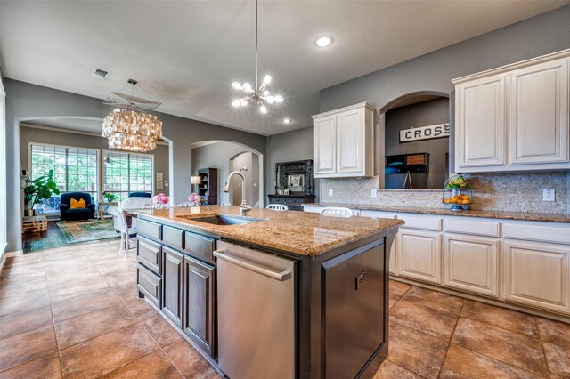 881 Willowmist Dr, Prosper, TX 75078 - kitchen with stainless steel dishwasher, a chandelier, arched walkways, backsplash, and a kitchen island with sink