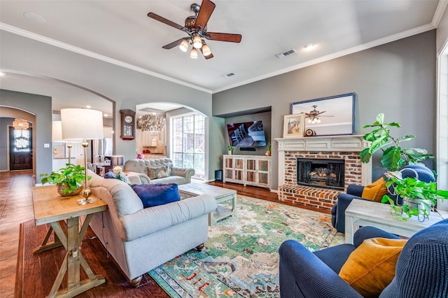 881 Willowmist Dr, Prosper, TX 75078 - living room featuring arched walkways, ceiling fan, crown molding, wood finished floors, and a brick fireplace