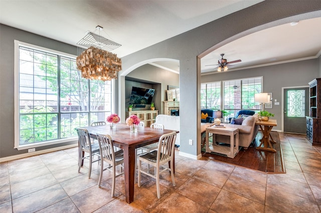 881 Willowmist Dr, Prosper, TX 75078 - dining room with ceiling fan, arched walkways, tile patterned flooring, a fireplace, and a chandelier