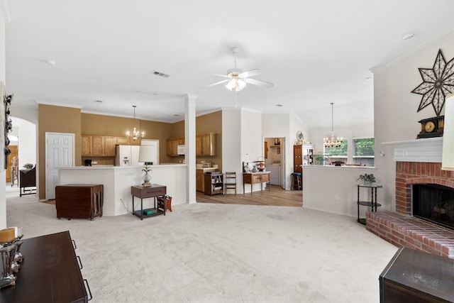 living room with visible vents, ornamental molding, ceiling fan with notable chandelier, and light colored carpet