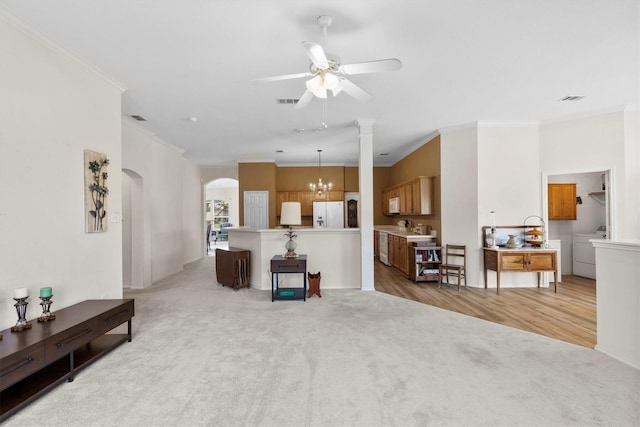 living room with arched walkways, light colored carpet, ceiling fan with notable chandelier, washer / clothes dryer, and crown molding