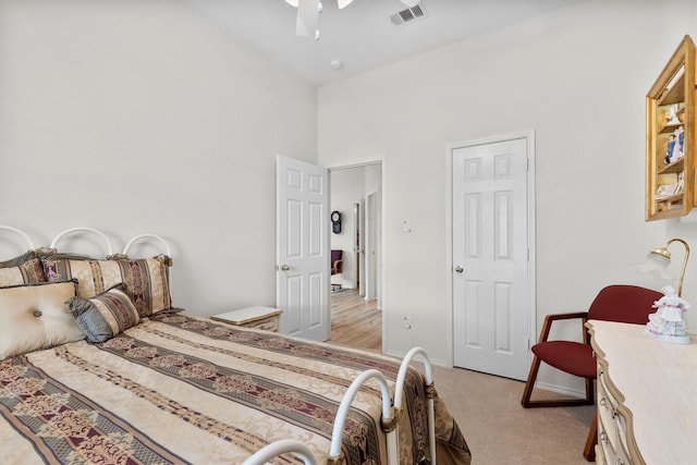 bedroom featuring light colored carpet, baseboards, visible vents, a ceiling fan, and high vaulted ceiling