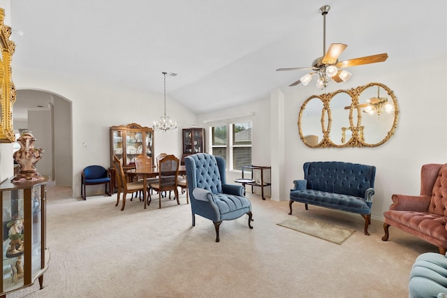 interior space featuring ceiling fan with notable chandelier, carpet flooring, vaulted ceiling, and arched walkways