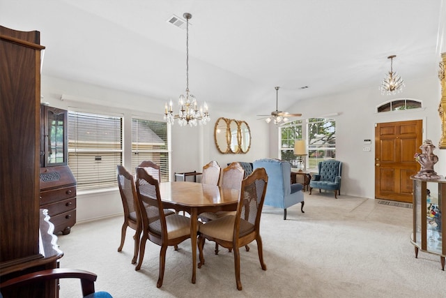 dining space featuring lofted ceiling, visible vents, light colored carpet, and ceiling fan with notable chandelier