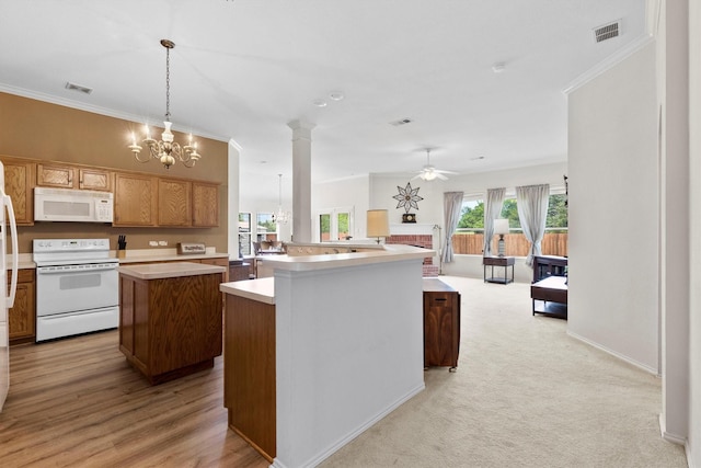 kitchen featuring visible vents, a kitchen island, light countertops, white appliances, and ceiling fan with notable chandelier