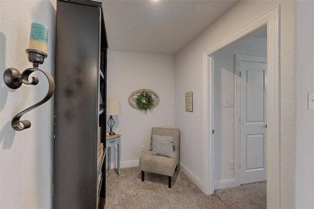 sitting room featuring light carpet and baseboards