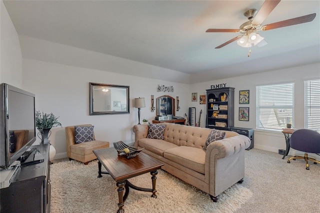 living room featuring ceiling fan, vaulted ceiling, light carpet, and baseboards