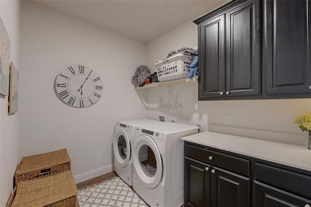 laundry area with cabinet space, baseboards, light wood-style flooring, and washer and clothes dryer