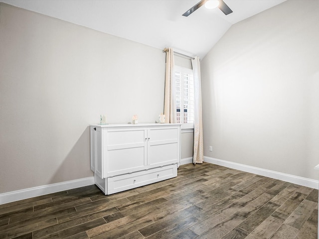 unfurnished bedroom featuring lofted ceiling, a ceiling fan, dark wood finished floors, and baseboards