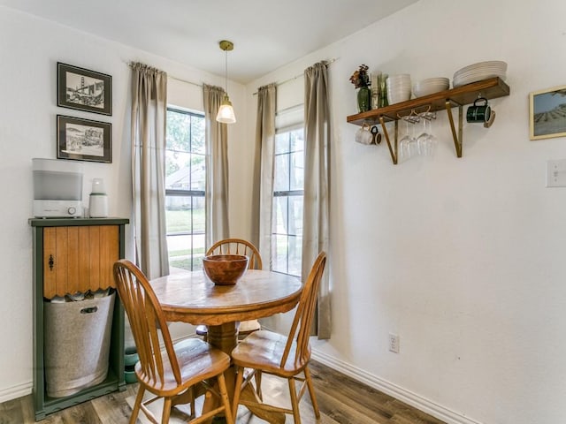 dining space with wood finished floors and baseboards