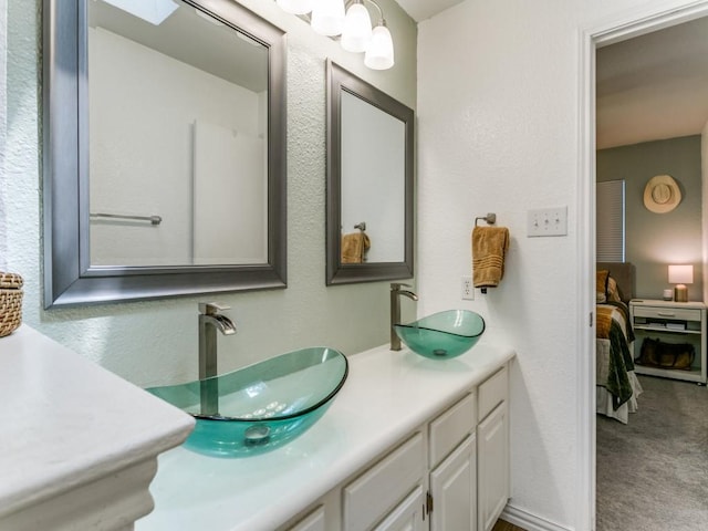 ensuite bathroom featuring ensuite bath, double vanity, and a sink