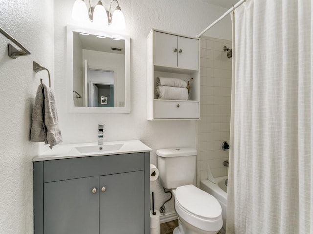 full bath with toilet, vanity, a textured wall, and shower / tub combo with curtain