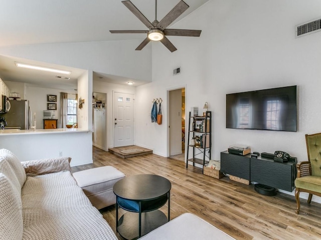 living area featuring visible vents, wood finished floors, a ceiling fan, and high vaulted ceiling