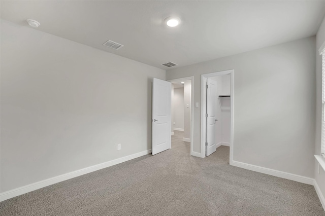 unfurnished bedroom featuring visible vents, light carpet, and baseboards