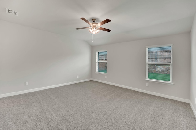 carpeted spare room featuring baseboards, visible vents, and a ceiling fan