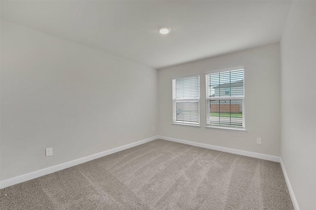 spare room featuring baseboards and carpet floors