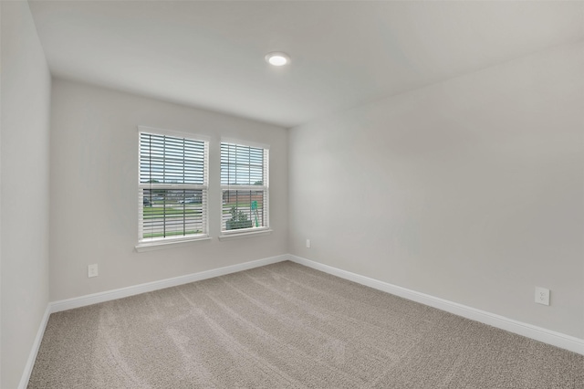 carpeted empty room featuring baseboards