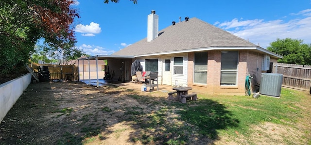209 Blossom Ln, Hurst, TX 76053 - rear view of house with brick siding, a chimney, central air condition unit, and a shingled roof