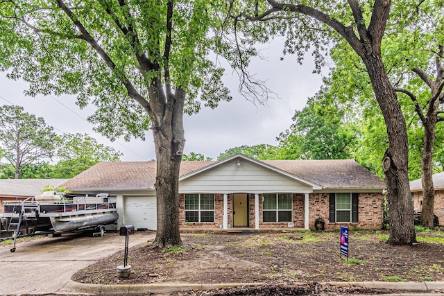 ranch-style house featuring covered porch, concrete driveway, brick siding, and a garage