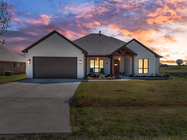 view of front facade with a porch, a front lawn, driveway, and an attached garage