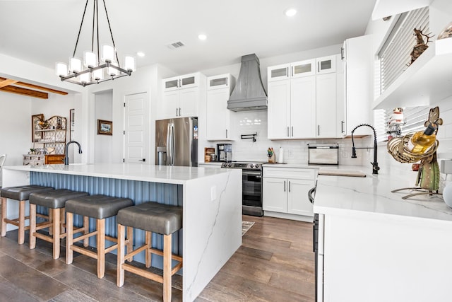 kitchen featuring tasteful backsplash, stainless steel appliances, custom range hood, a sink, and visible vents