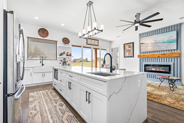 kitchen featuring white cabinets, a sink, ceiling fan, and stainless steel fridge with ice dispenser