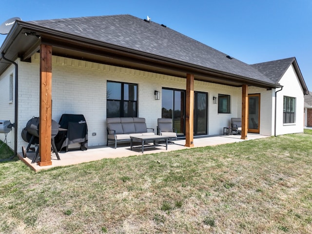 rear view of house featuring a lawn, roof with shingles, a patio area, and brick siding