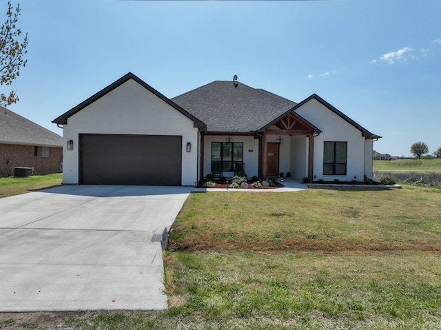view of front of house with driveway, a front yard, a shingled roof, and a garage